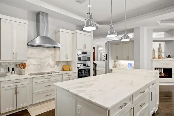 a dining hall with stainless steel appliances kitchen island granite countertop a dining table and chairs