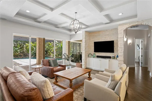 a living room with furniture a fireplace and a chandelier