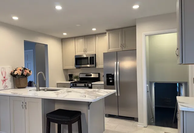 a kitchen with stainless steel appliances granite countertop a refrigerator and a stove