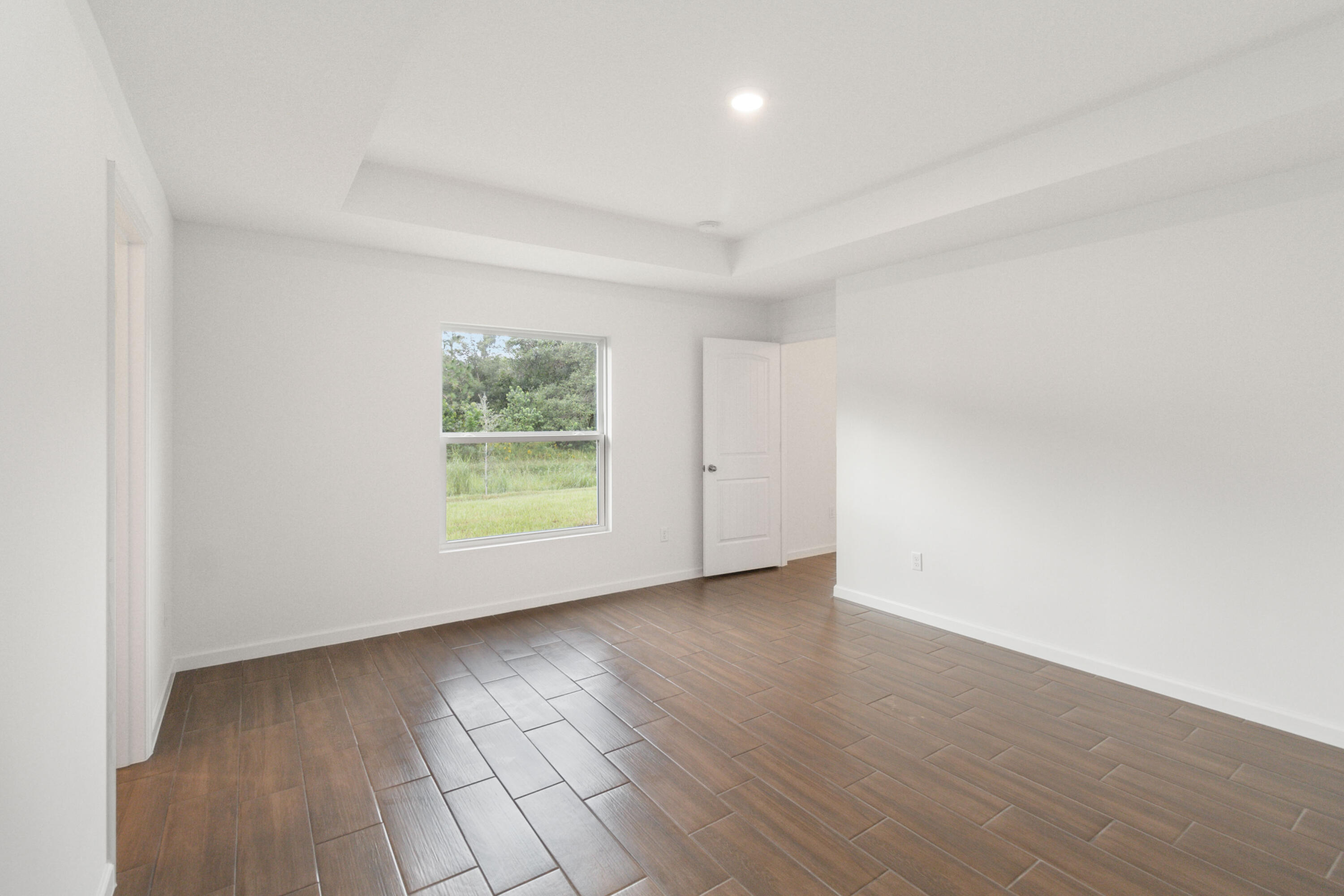 336 Rheine Road Northwest Palm Bay, FL 32907 - Photo 18 of 30 an empty room with wooden floor and windows