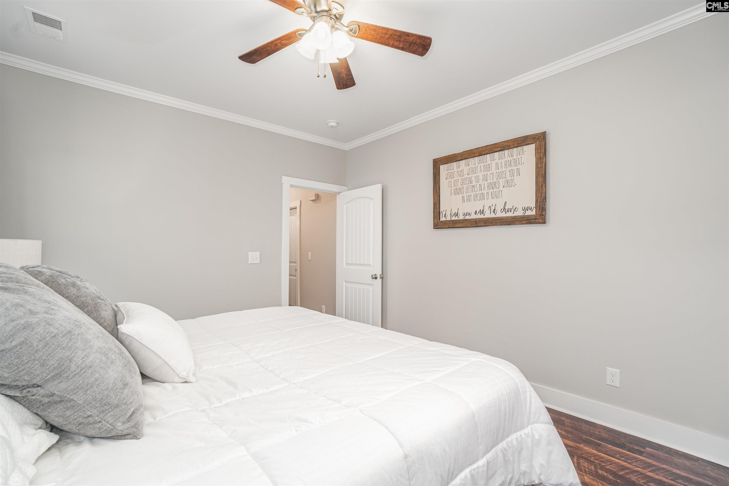 649 Sandbar Road Chapin, SC 29036 - Photo 23 of 40 a bedroom with a large bed and a chandelier