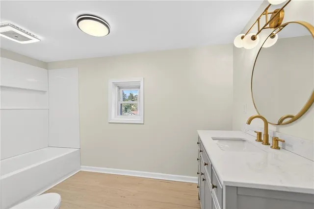 a bathroom with a toilet a sink and mirror