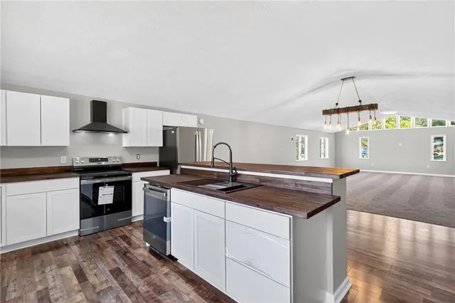 a kitchen with stainless steel appliances granite countertop a sink stove and cabinets