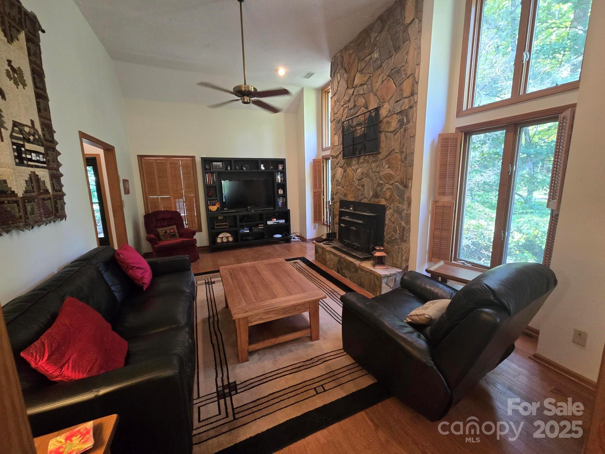 352 Bolt Road Lake Lure, NC 28746 - Photo 5 of 31 a living room with furniture a flat screen tv and a fireplace