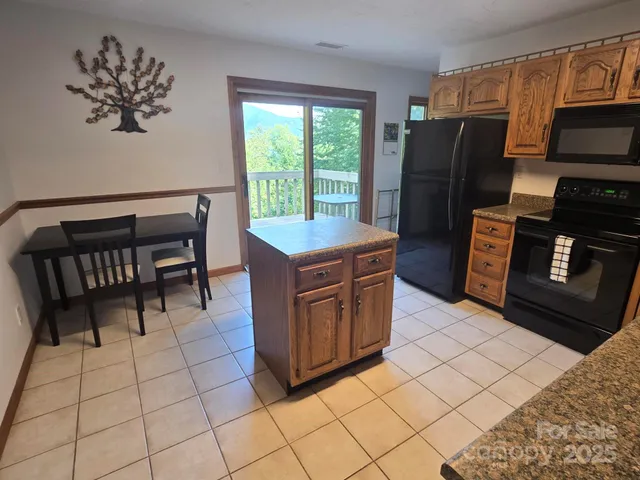 a kitchen with stainless steel appliances a stove a refrigerator a sink a counter top space and cabinets