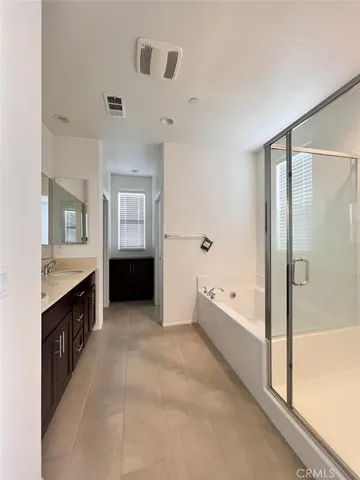 a spacious bathroom with a tub sink and mirror