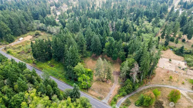 an aerial view of residential house with outdoor space and trees all around