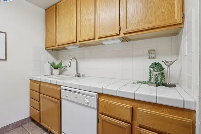 a kitchen with stainless steel appliances granite countertop a sink a refrigerator and cabinets