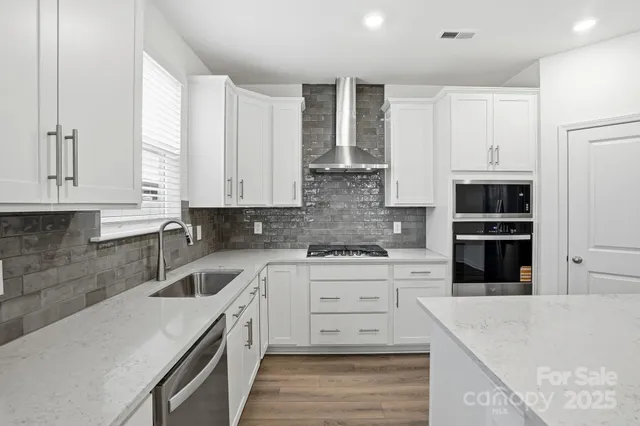 a kitchen with stainless steel appliances kitchen island granite countertop a sink and cabinets
