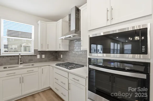 a kitchen with granite countertop white cabinets and appliances