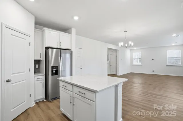 a view of a kitchen with refrigerator and wooden floor