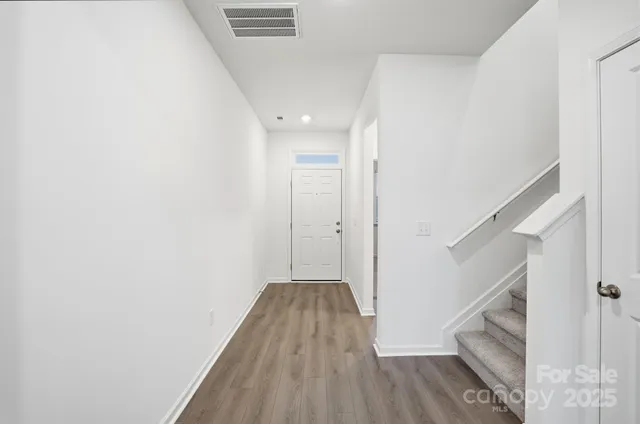 a view of hallway with stairs and wooden floor
