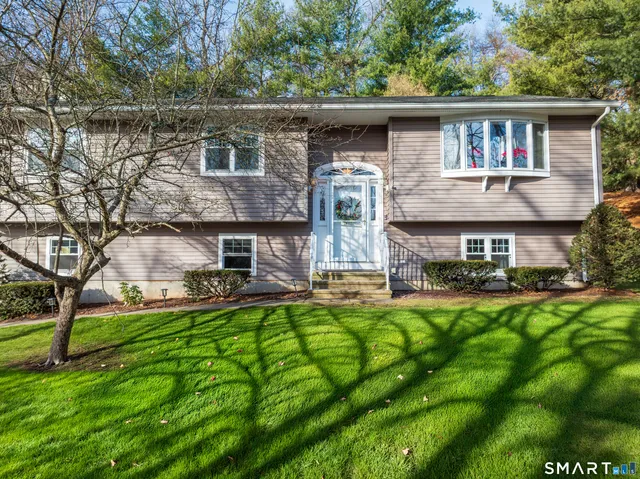 a front view of house with yard and trees in the background
