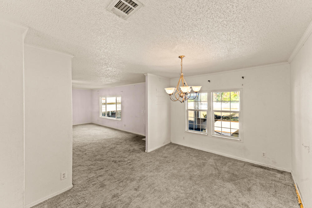 5710 US 90 Lee, FL 32059 - Photo 11 of 38 an empty room with chandelier and glass door