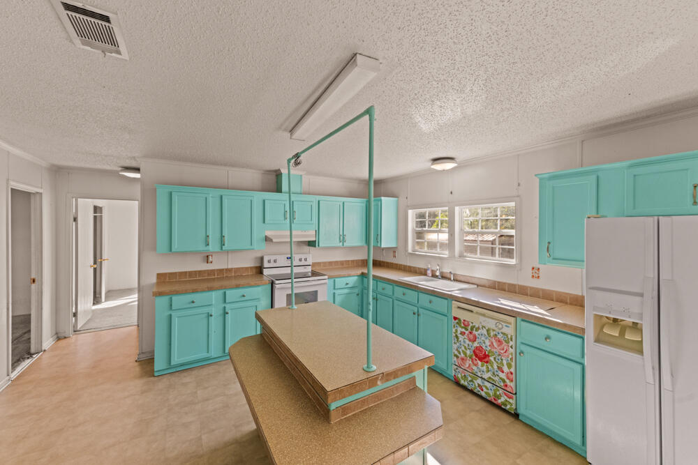 5710 US 90 Lee, FL 32059 - Photo 13 of 38 a kitchen with stainless steel appliances granite countertop a refrigerator and a stove