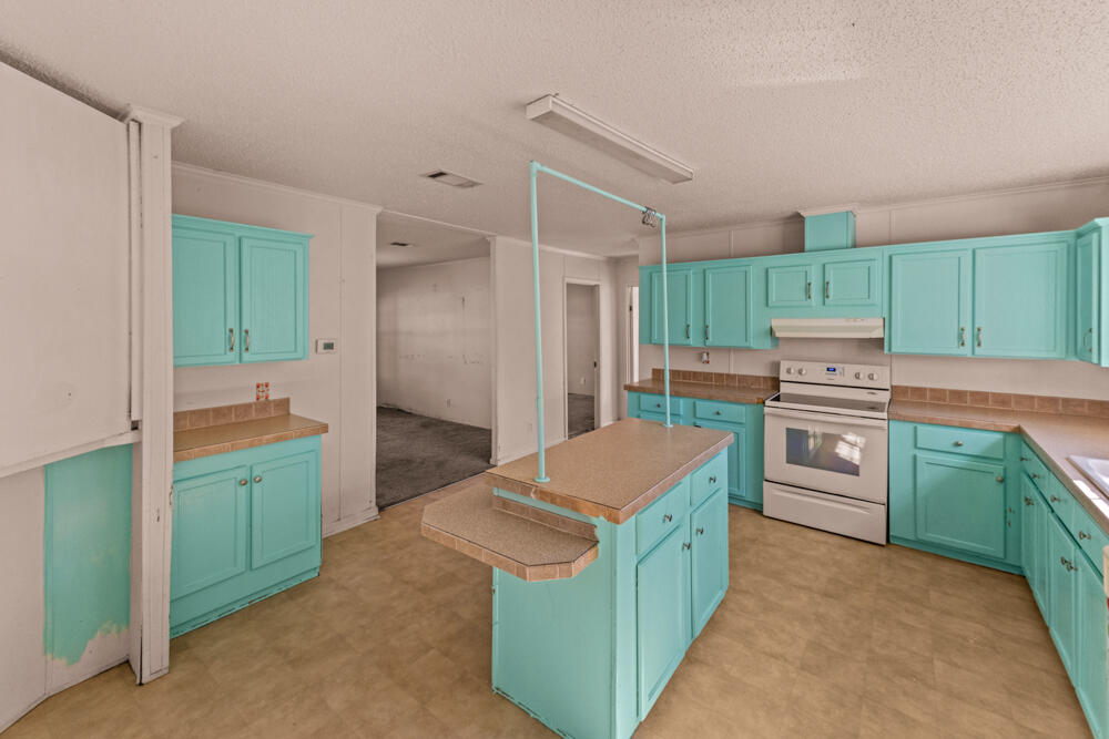 5710 US 90 Lee, FL 32059 - Photo 16 of 38 a kitchen with kitchen island a sink a stove and a refrigerator