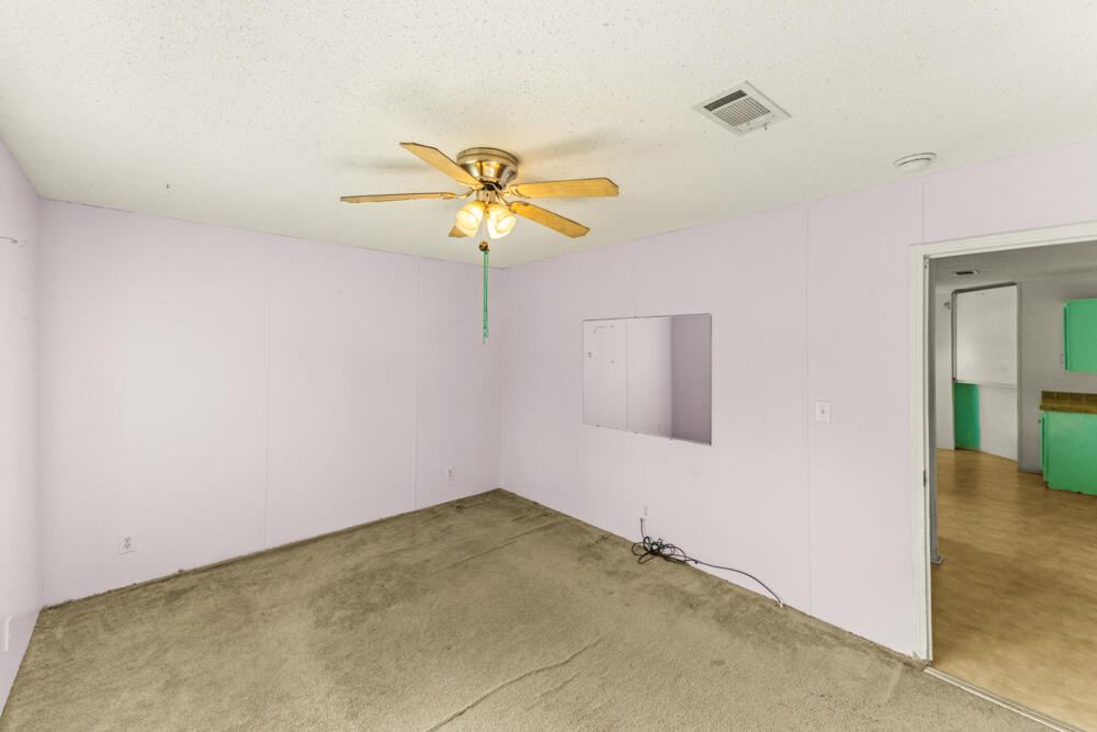 5710 US 90 Lee, FL 32059 - Photo 20 of 38 an empty room with a chandelier fan and a table
