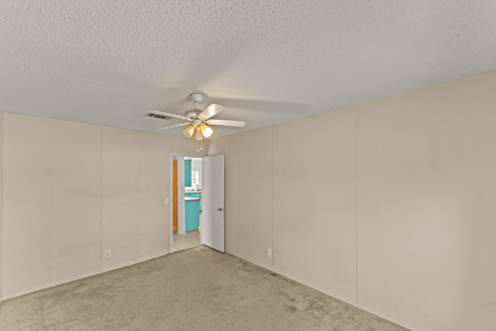 5710 US 90 Lee, FL 32059 - Photo 25 of 38 an empty room with an entryway and chandelier fan