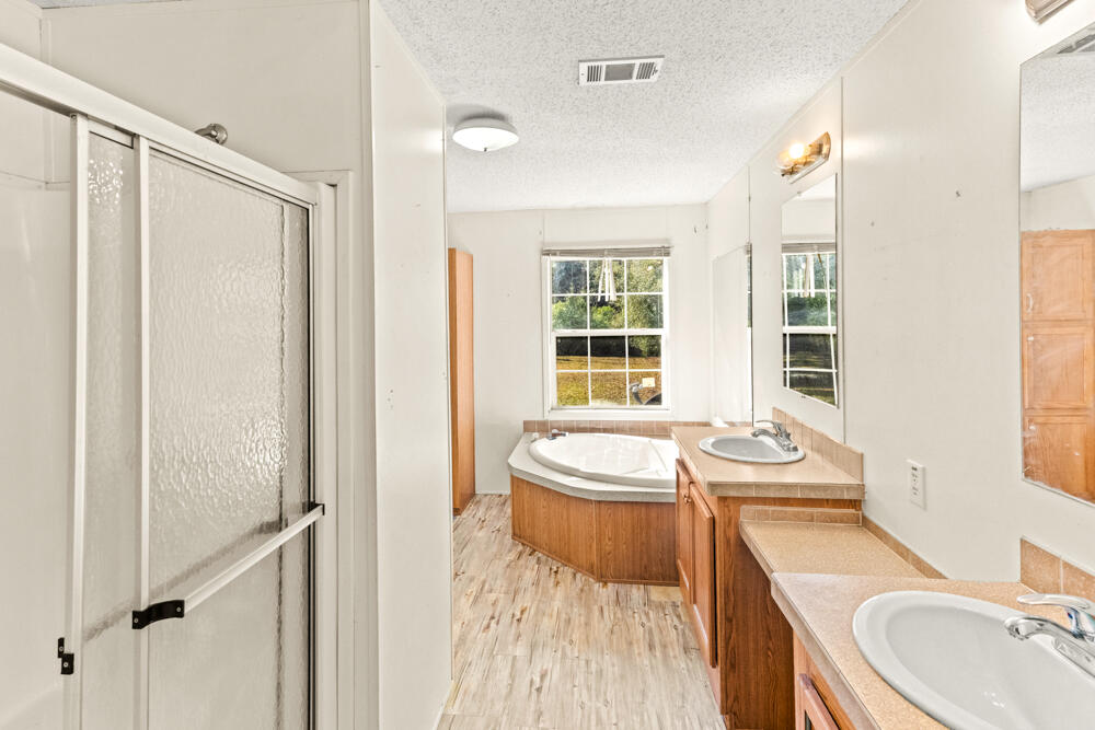 5710 US 90 Lee, FL 32059 - Photo 28 of 38 a bathroom with a sink a toilet a mirror and shower