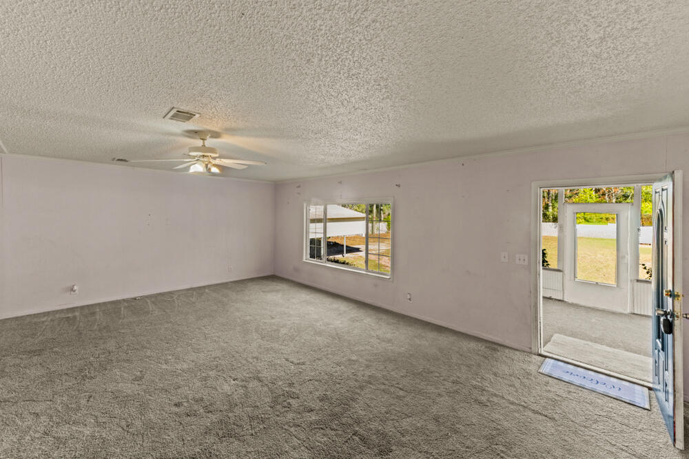 5710 US 90 Lee, FL 32059 - Photo 5 of 38 an empty room with windows and chandelier fan