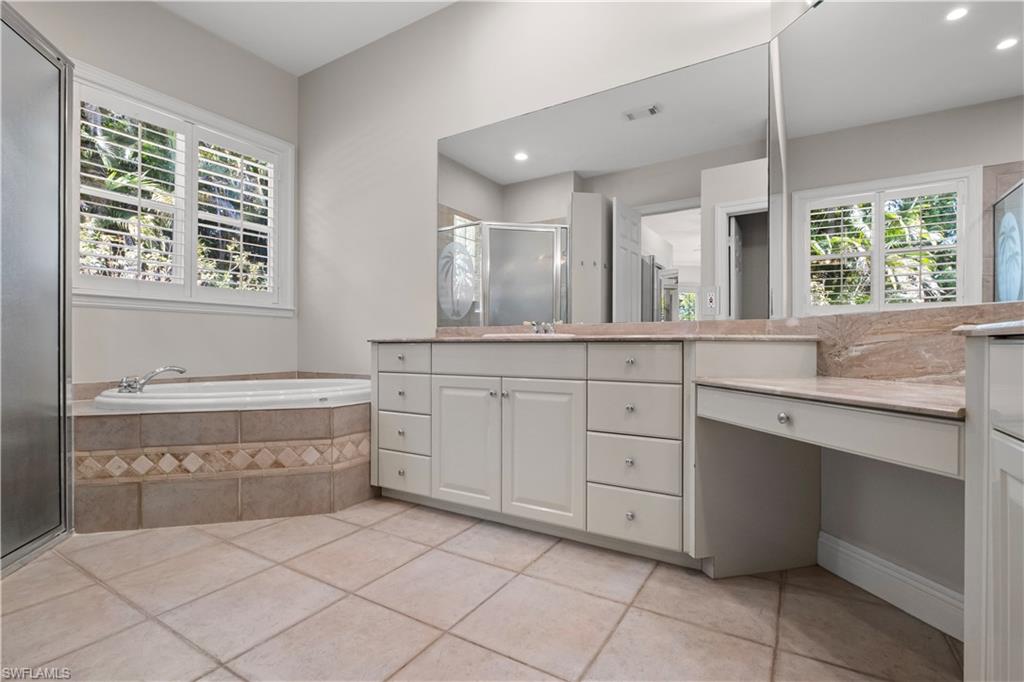 6800 Hunters Road Naples, FL 34109 - Photo 11 of 16 Bathroom with a shower stall, vanity, a garden tub, and plenty of natural light