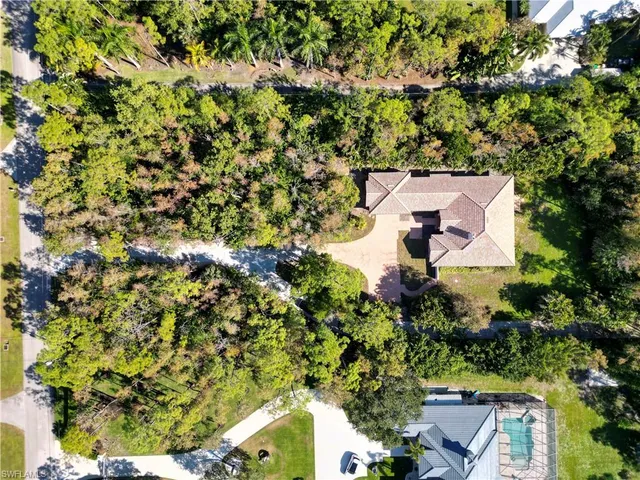 an aerial view of a house with a yard and trees