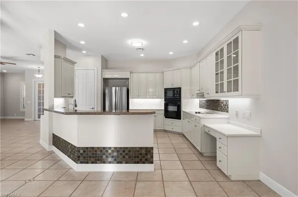 a large kitchen with kitchen island a counter top stainless steel appliances and cabinets