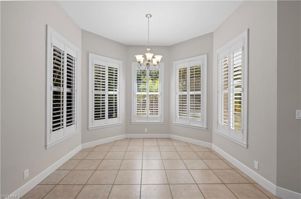 6800 Hunters Road Naples, FL 34109 - Photo 5 of 16 Unfurnished dining area with light tile patterned floors and a chandelier