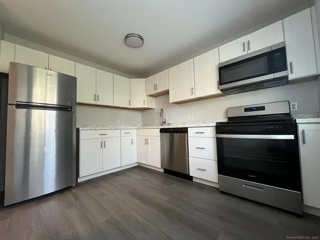 a kitchen with white cabinets and stainless steel appliances