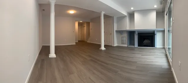 an empty room with wooden floor and entrance