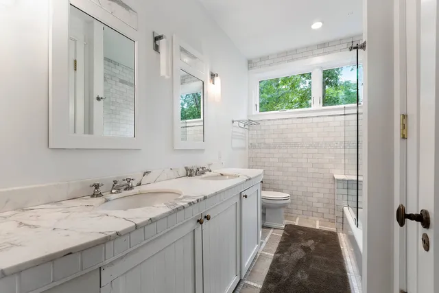 a bathroom with a granite countertop sink a large mirror a and a shower