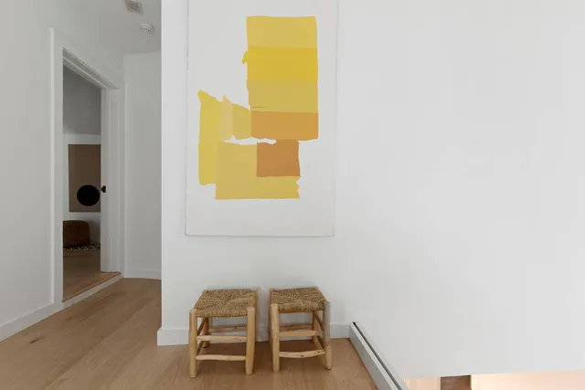 a view of a hallway with wooden floor and a bathroom