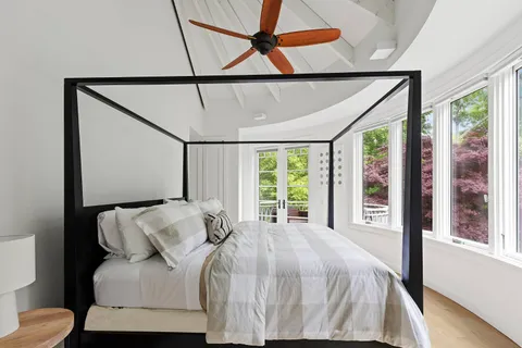 a bed sitting in a bedroom next to a window