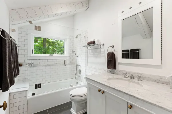 a bathroom with a granite countertop sink toilet and shower