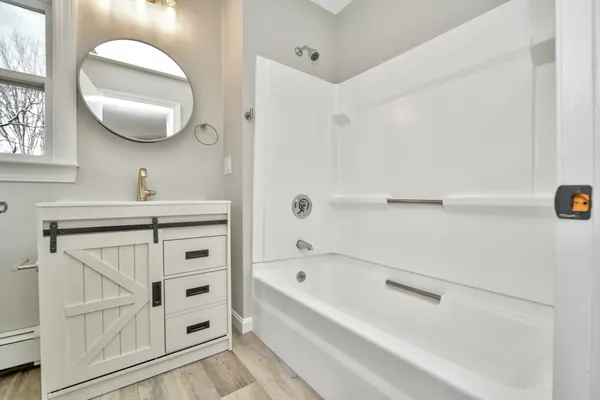 a bathroom with a sink a vanity a mirror and a bathtub