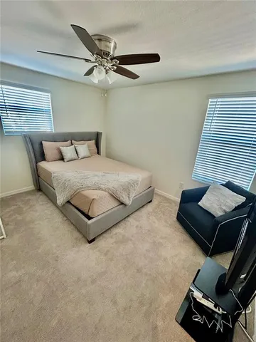 a bedroom with a bed furniture and a flat screen tv