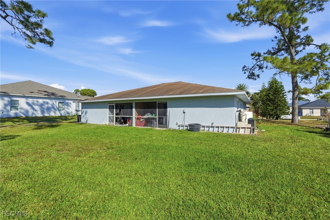 4741-4743 27th Street Southwest Lehigh Acres, FL 33973 - Photo 13 of 13 a view of a house with a big yard potted plants and large tree