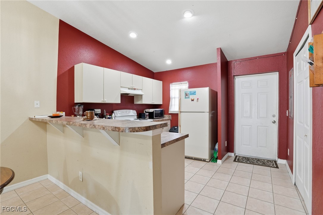 4741-4743 27th Street Southwest Lehigh Acres, FL 33973 - Photo 7 of 13 a kitchen with refrigerator and mirror