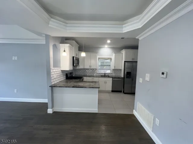 a kitchen with stainless steel appliances granite countertop a refrigerator and a stove