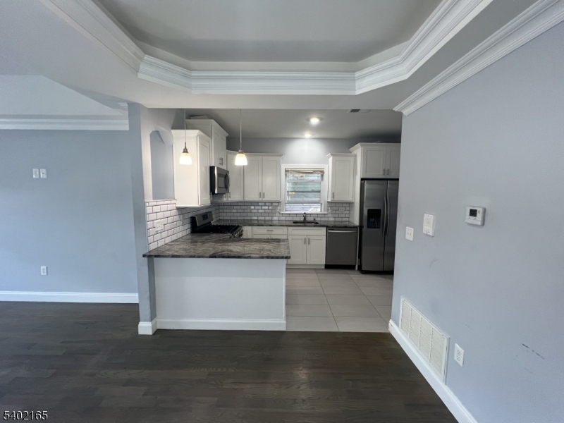 454 3rd Avenue Elizabeth Port, NJ 07206 - Photo 10 of 11 a kitchen with stainless steel appliances granite countertop a stove a sink and a refrigerator