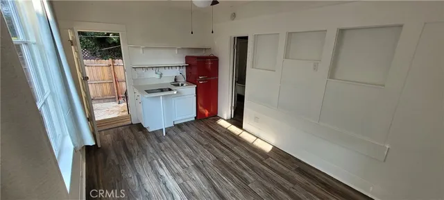 a kitchen with wooden floors and stainless steel appliances