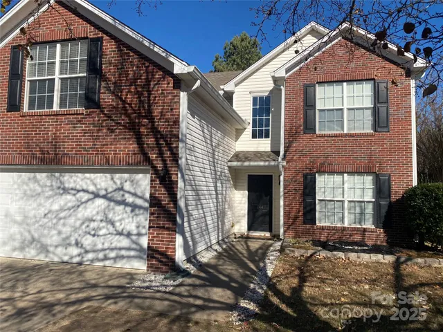 a view of a brick house with large windows