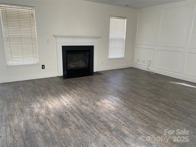 a view of empty room with wooden floor and fireplace