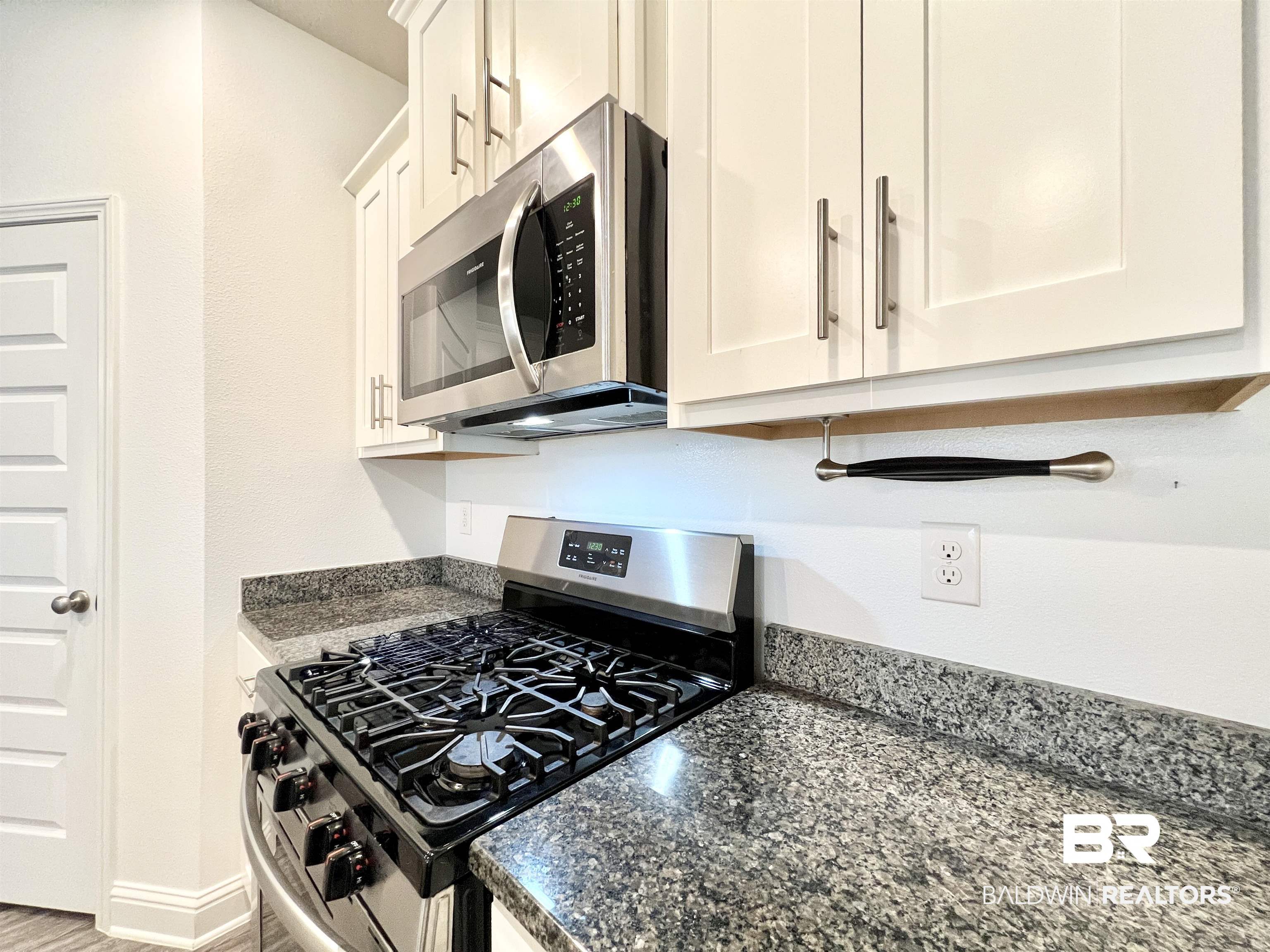 24785 Slater Mill Road Daphne, AL 36526 - Photo 5 of 46 Kitchen with white cabinetry, stainless steel appliances, wood-type flooring, and dark stone counters