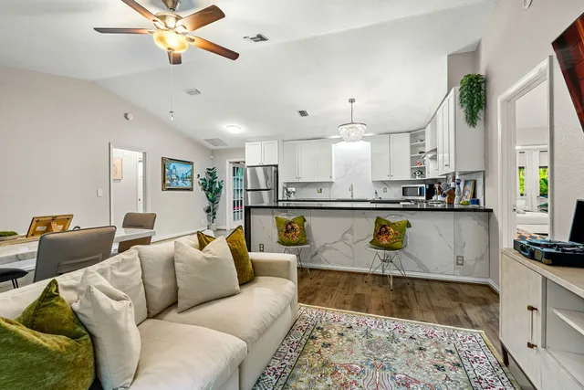 a living room with furniture and kitchen view