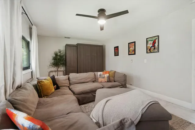 a living room with furniture and a ceiling fan