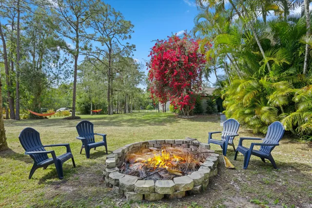 a view of a chairs and table in the backyard