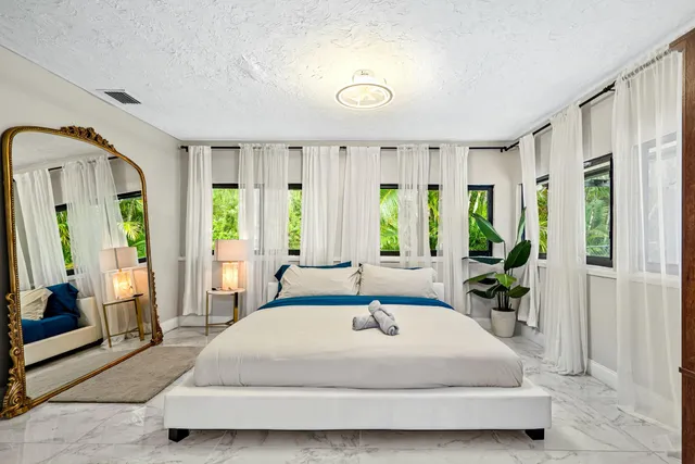 a spacious bedroom with a large bed and a large window