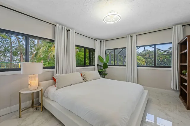 a bedroom with a large bed and a large window