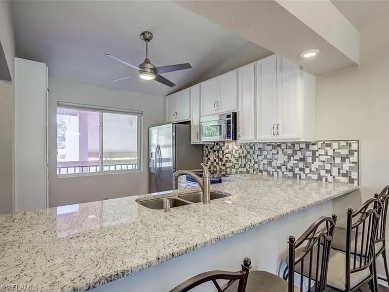 a kitchen with granite countertop a sink a window and stainless steel appliances